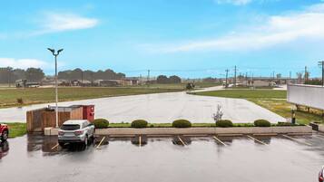 A parking lot with a few cars and a building in the background.