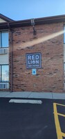 Un edificio de ladrillo con un letrero que indica que es un hotel: Red Lion Inn & Suites.