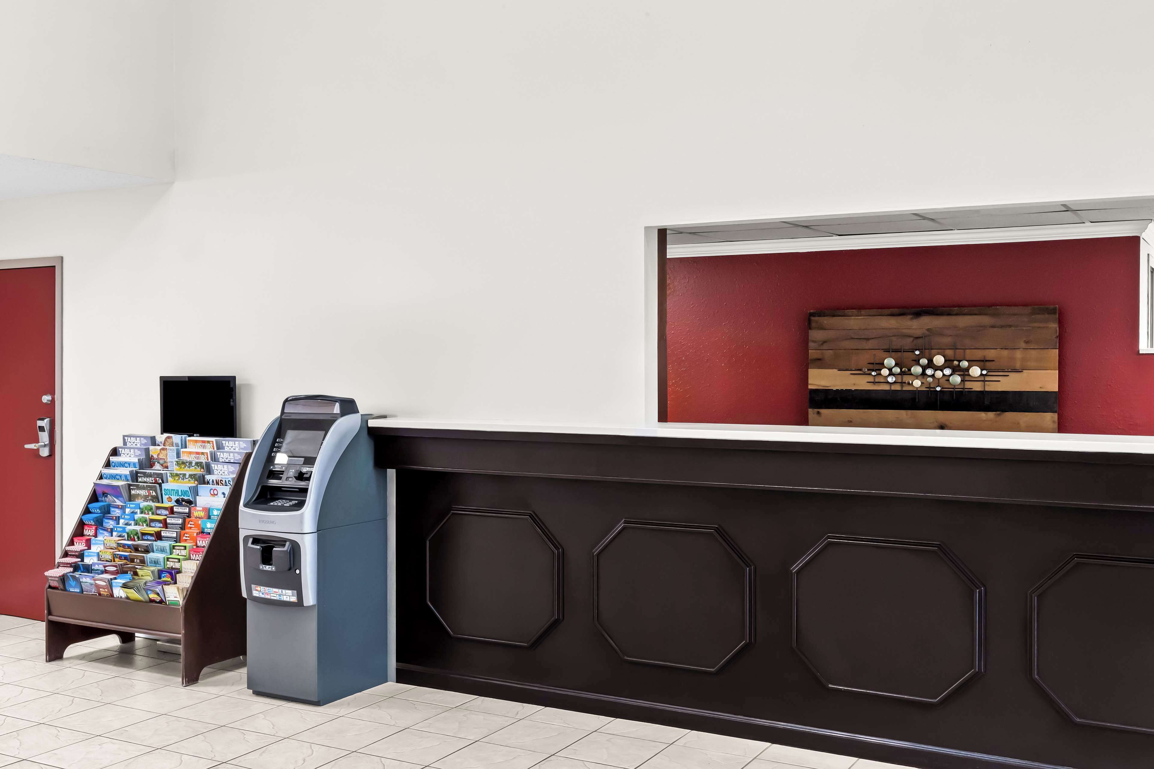 A reception area with a vending machine, a magazine rack, and a wooden panel wall.