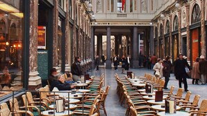 A spacious indoor public area with multiple tables and chairs, featuring a central open space and ornate architectural details. - The Usual Brussels (Brussels)