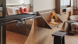 A modern hotel room with a curved seating area, a flat-screen TV, and a coffee table. - The Usual Brussels (Brussels)