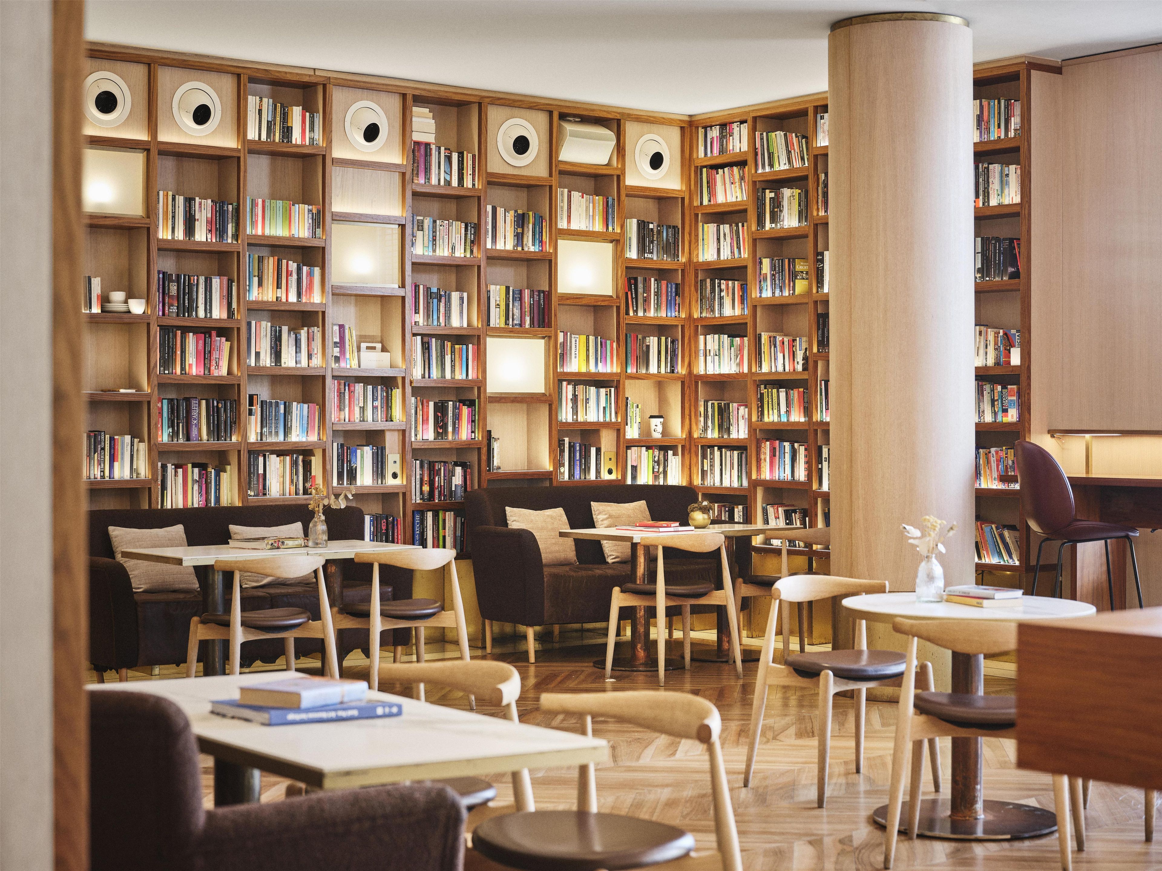 Una biblioteca con varias estanterías, zonas de estar y mesas.