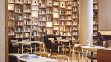 Una biblioteca con varias estanterías, zonas de estar y mesas.