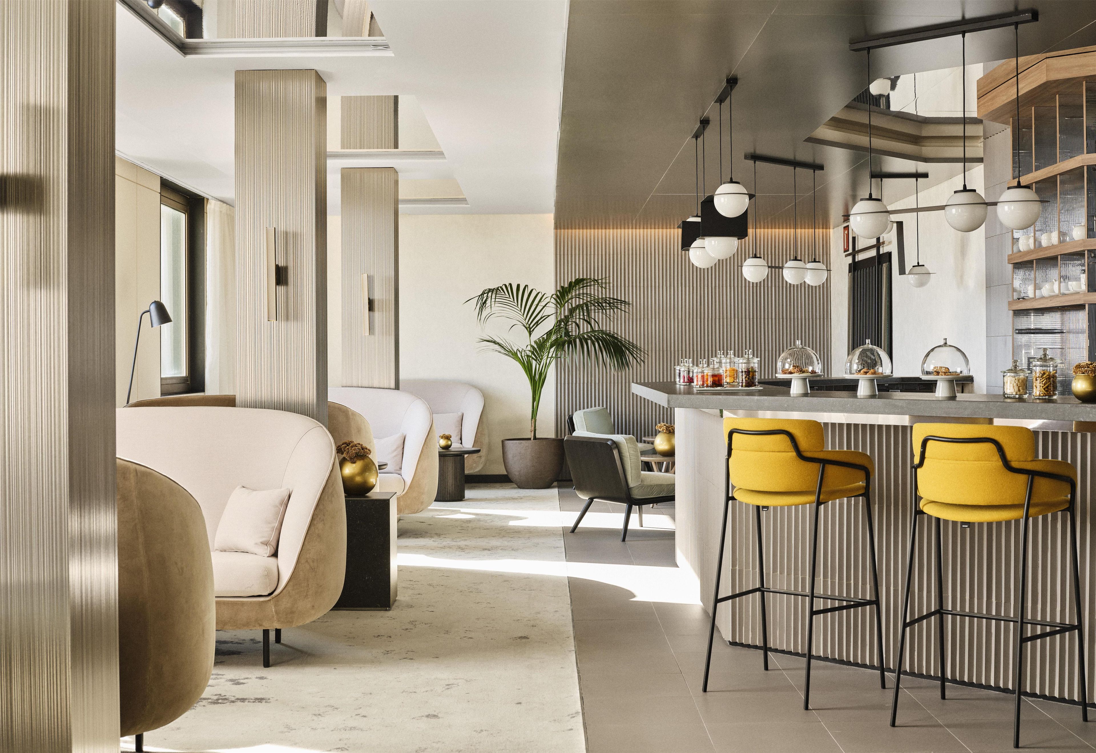A modern interior with a bar area, seating, and a large plant.