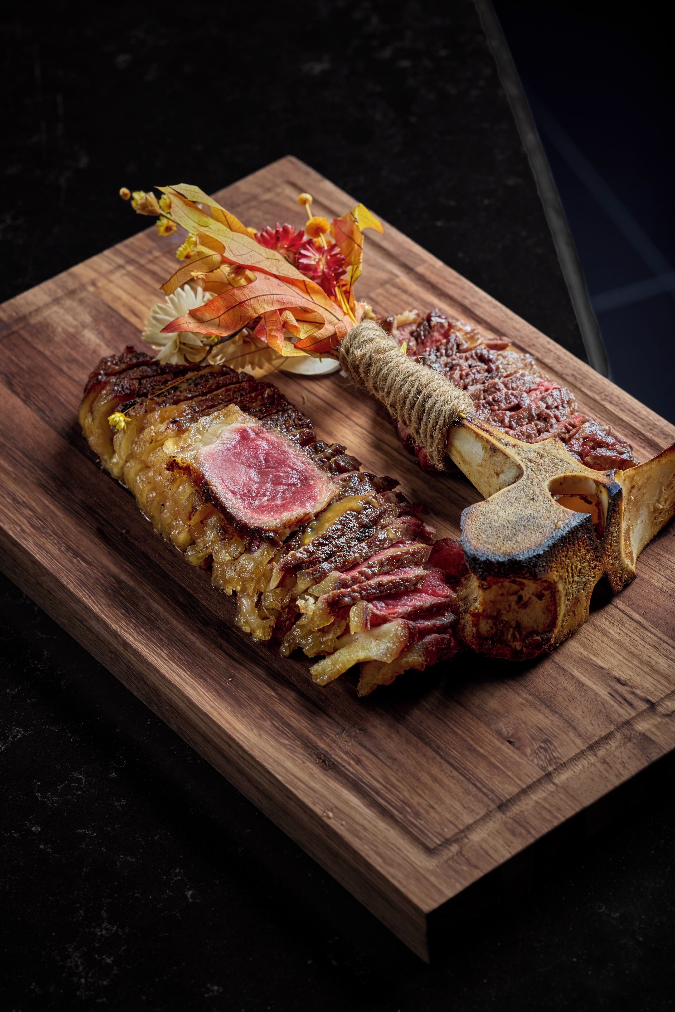 Una tabla de madera con una variedad de alimentos, entre ellos carne y verduras en porciones.