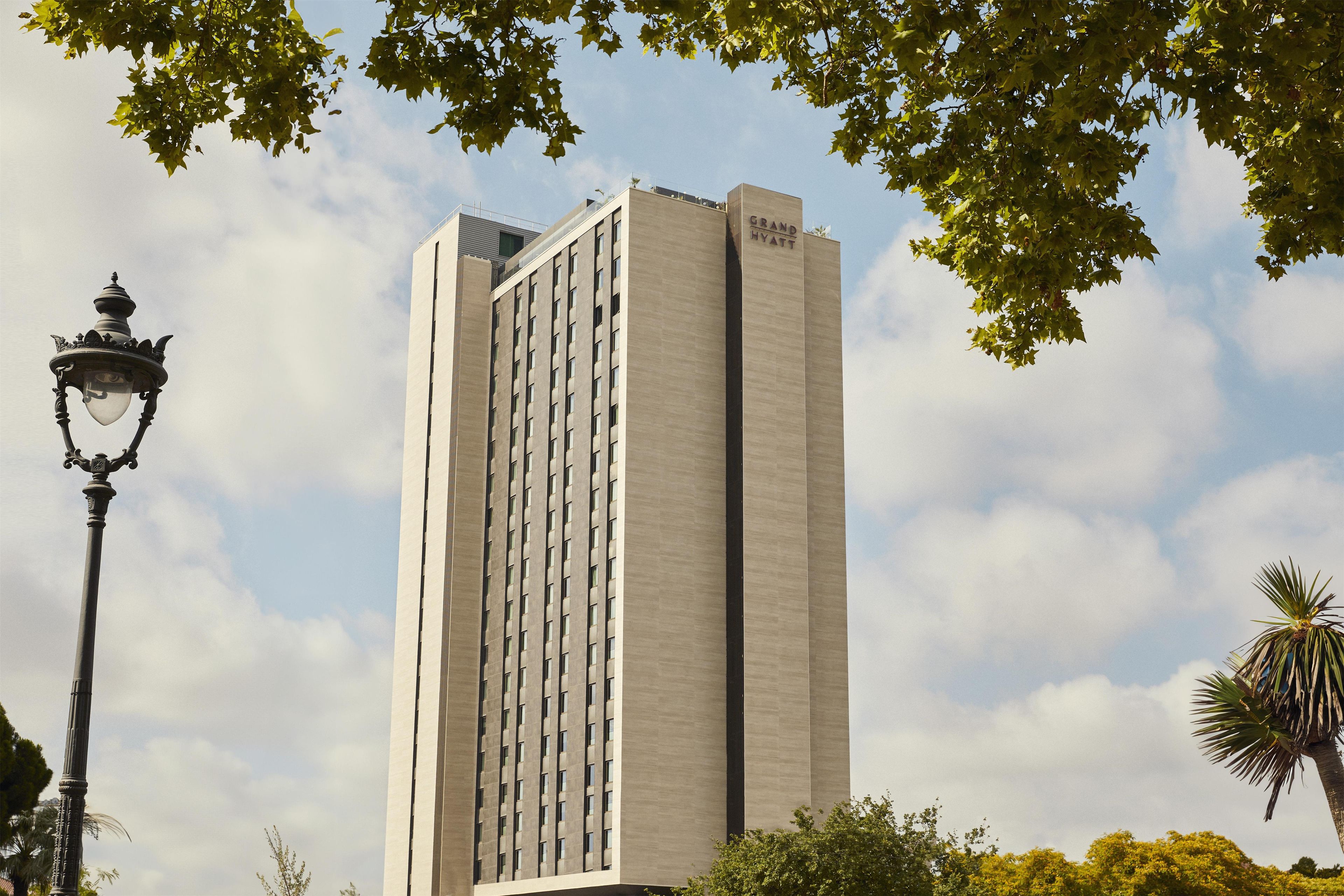 Un grand bâtiment d’hôtel de forme rectangulaire, doté d’un design moderne et d’une enseigne bien visible sur sa façade.