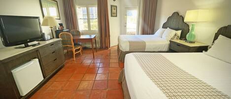 A hotel room with a bed, a desk, a television, and a chair.