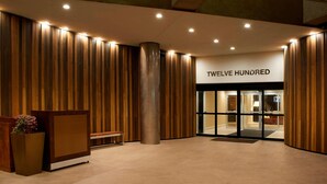A hotel entrance with a wooden facade, a reception desk, and a sign reading "TWELVE HUNDRED". - Marriott Columbia (Columbia)