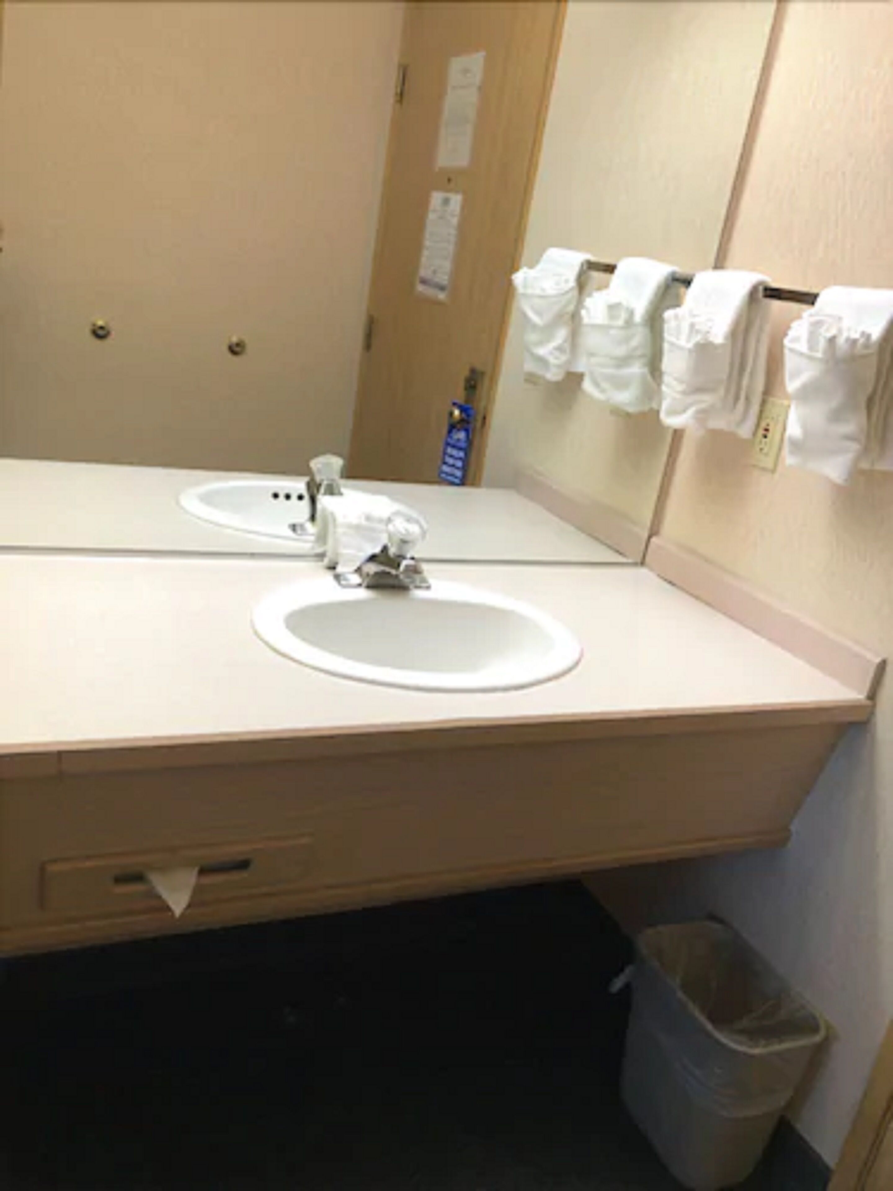 A bathroom with a sink, mirror, and towel rack.