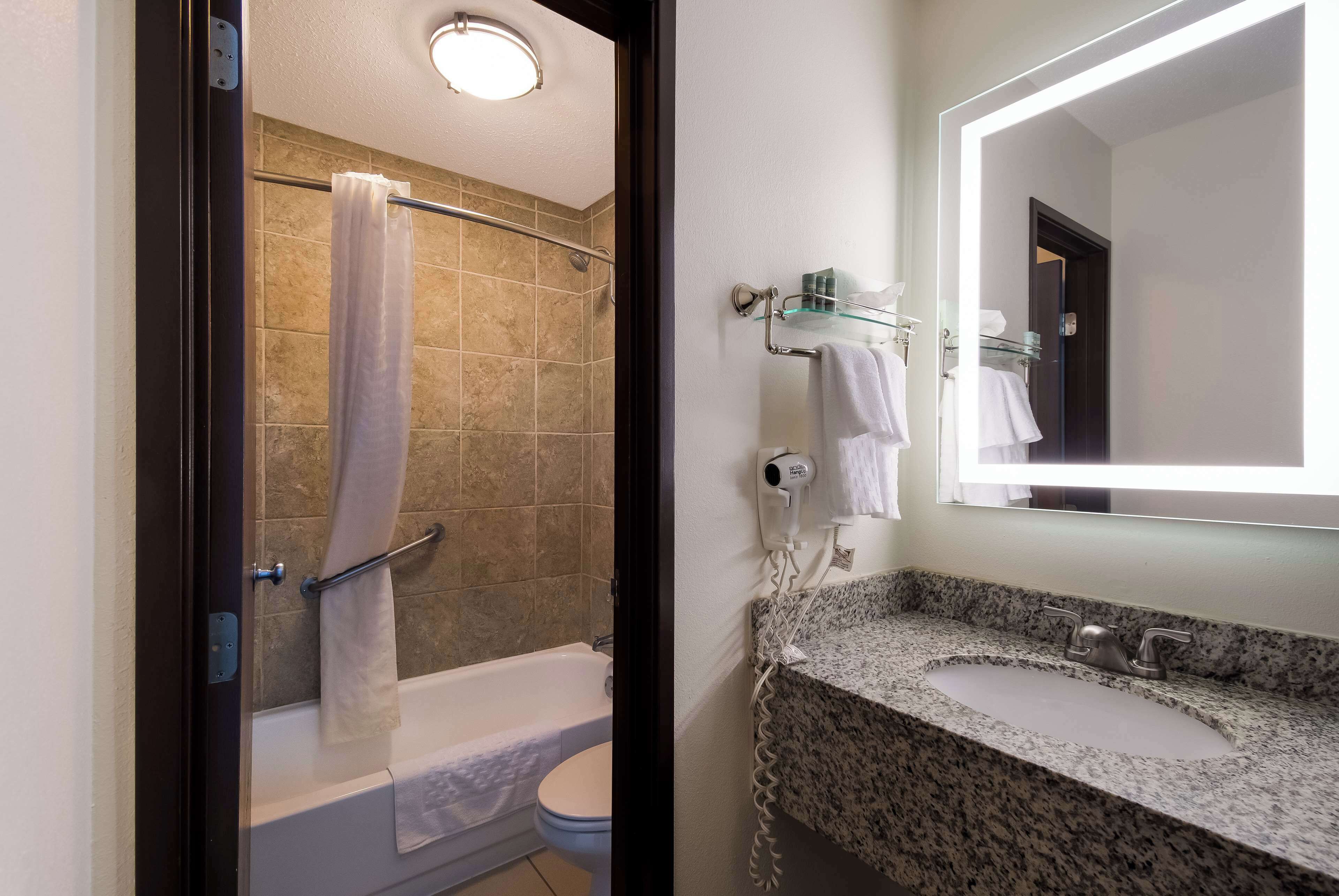 A bathroom with a shower, toilet, and sink.