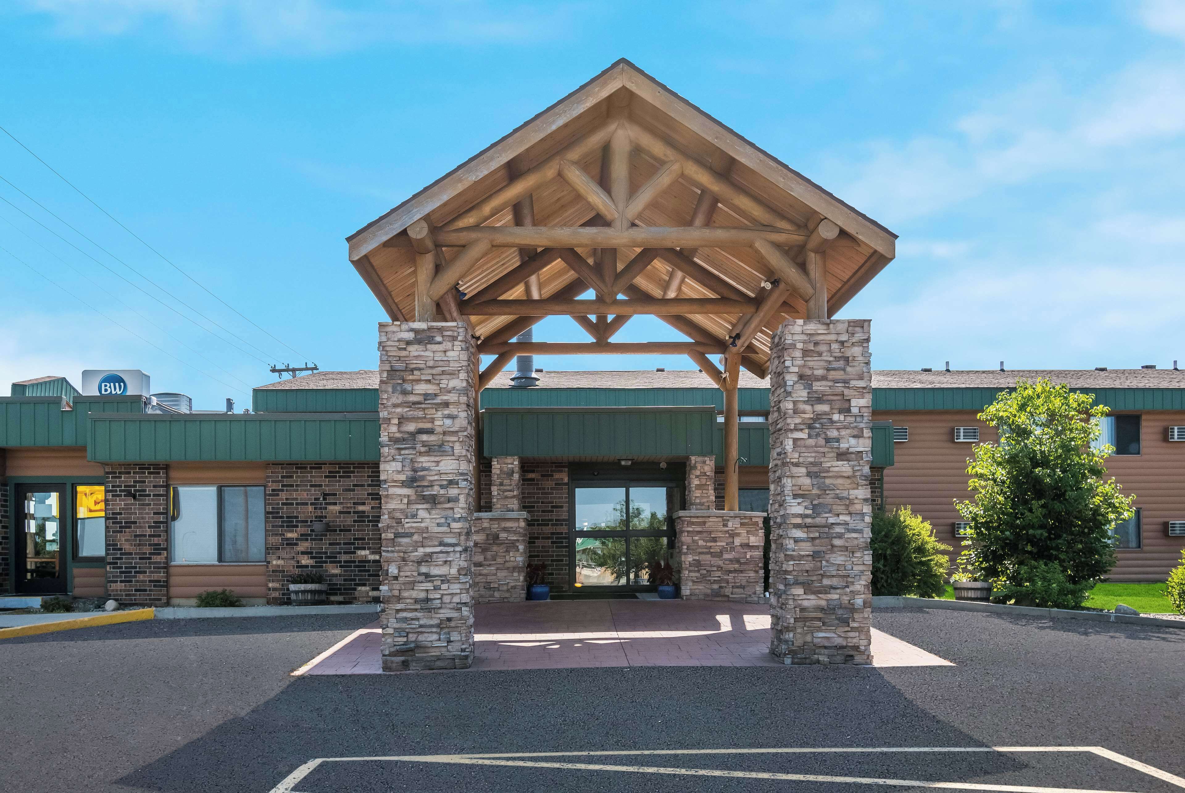 A building with a covered entrance, stone pillars, and a brick facade.