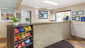 A reception area with a granite counter, a plant, and a snack shelf. - Best Western Mountainbrook Inn (Maggie Valley)