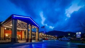 A hotel with a covered outdoor area, an American flag, and a sign for Best Western Mountainbrook Inn. - Best Western Mountainbrook Inn (Maggie Valley)