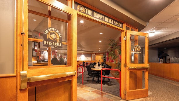 A bar and grill with wooden doors and a tiled floor.