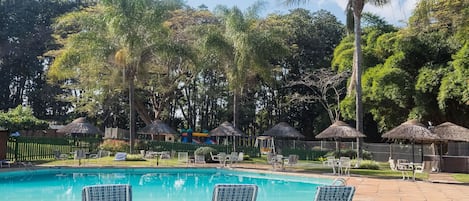 Una piscina al aire libre, sombrillas, tumbonas