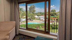 Una habitación con un ventanal grande que da a una piscina y un jardín.