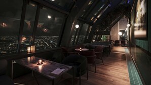 A rooftop bar with tables and chairs, large windows with city views, and hanging plants. - Radisson Blu Plaza Hotel, Oslo (Oslo)