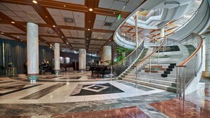 A spacious lobby with a marble floor, large columns, and a central staircase with a glass railing. - Radisson Blu Plaza Hotel, Oslo (Oslo)