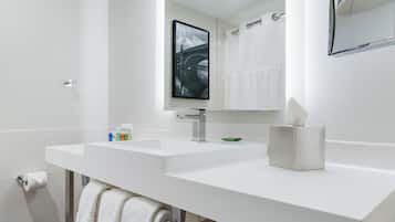 Un baño moderno con dos lavamanos, un espejo grande y un perchero para toallas.