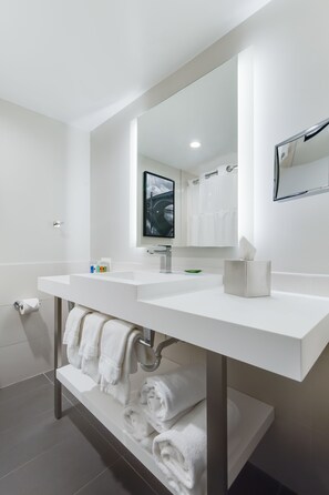 Een bad/douchecombinatie, designer toiletartikelen, een haardroger