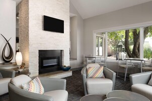 Una sala de estar moderna con chimenea, asientos cómodos y vistas al exterior.