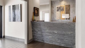 A reception area with a stone wall, framed artwork, and a modern light fixture.
