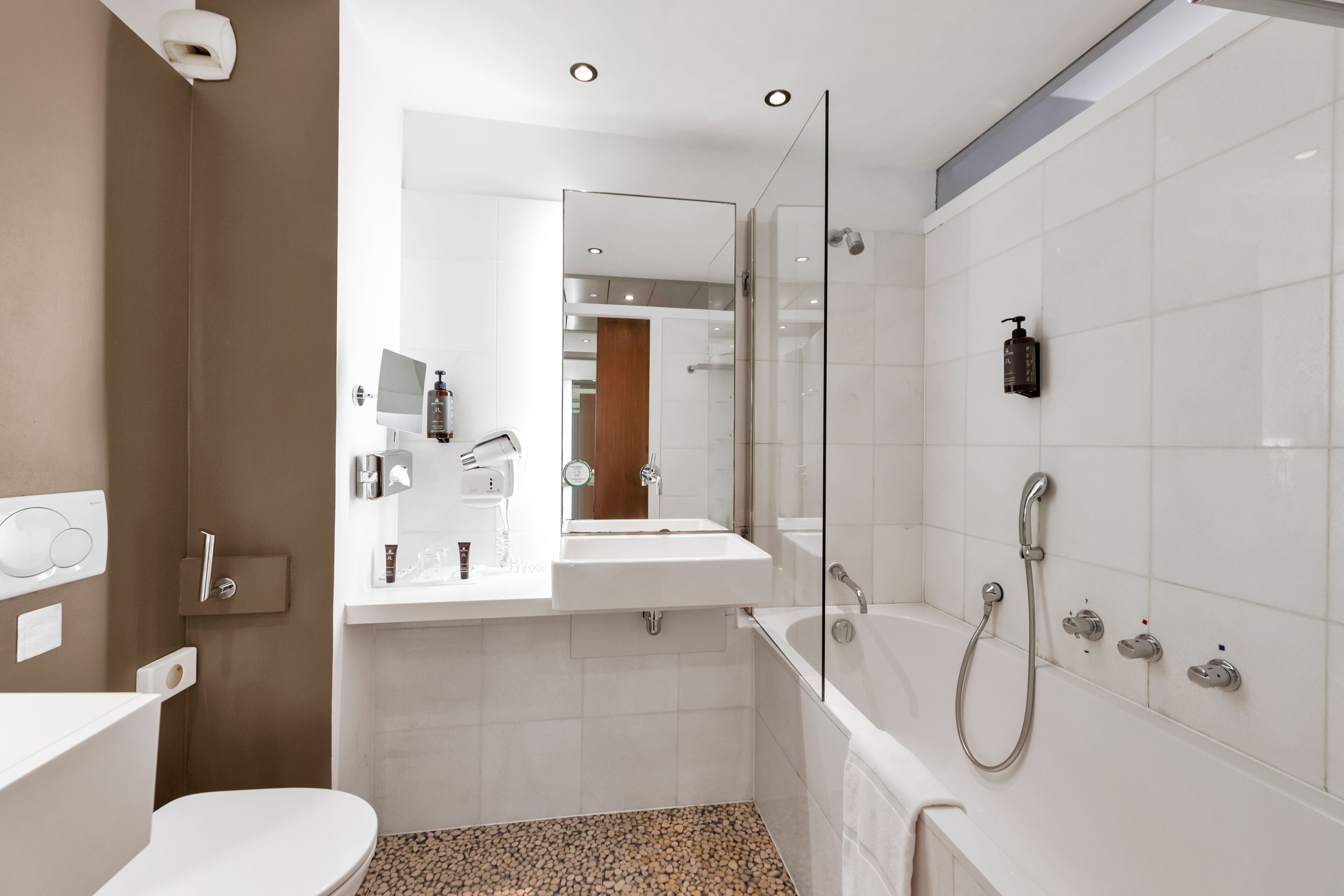 A modern bathroom with a toilet, sink, and bathtub.
