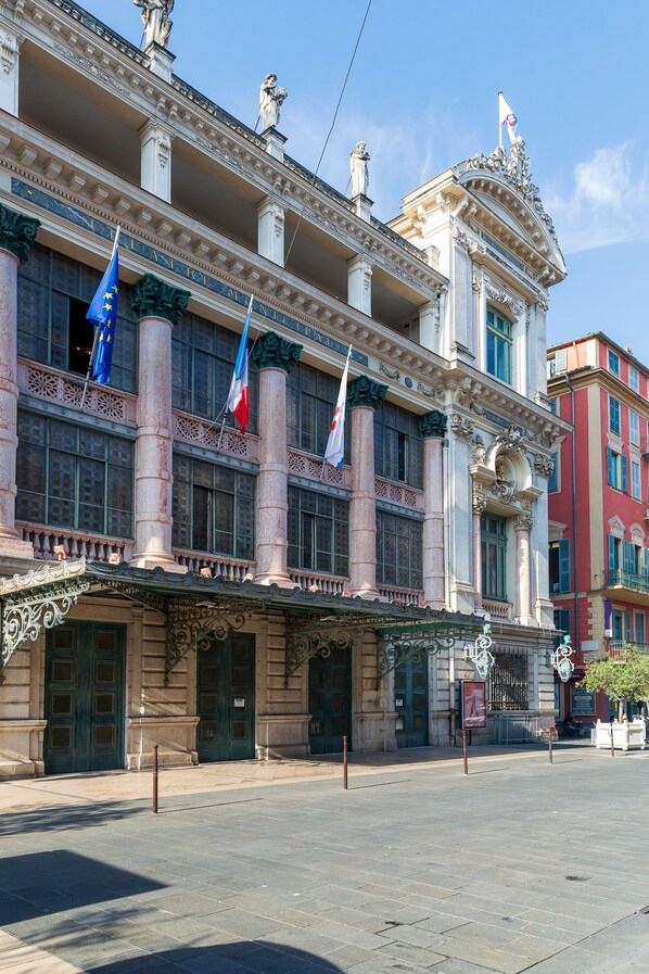 A historic building with classical architecture, featuring multiple flags, large windows, and ornate balconies. - Hotel Beau Rivage (Nice)
