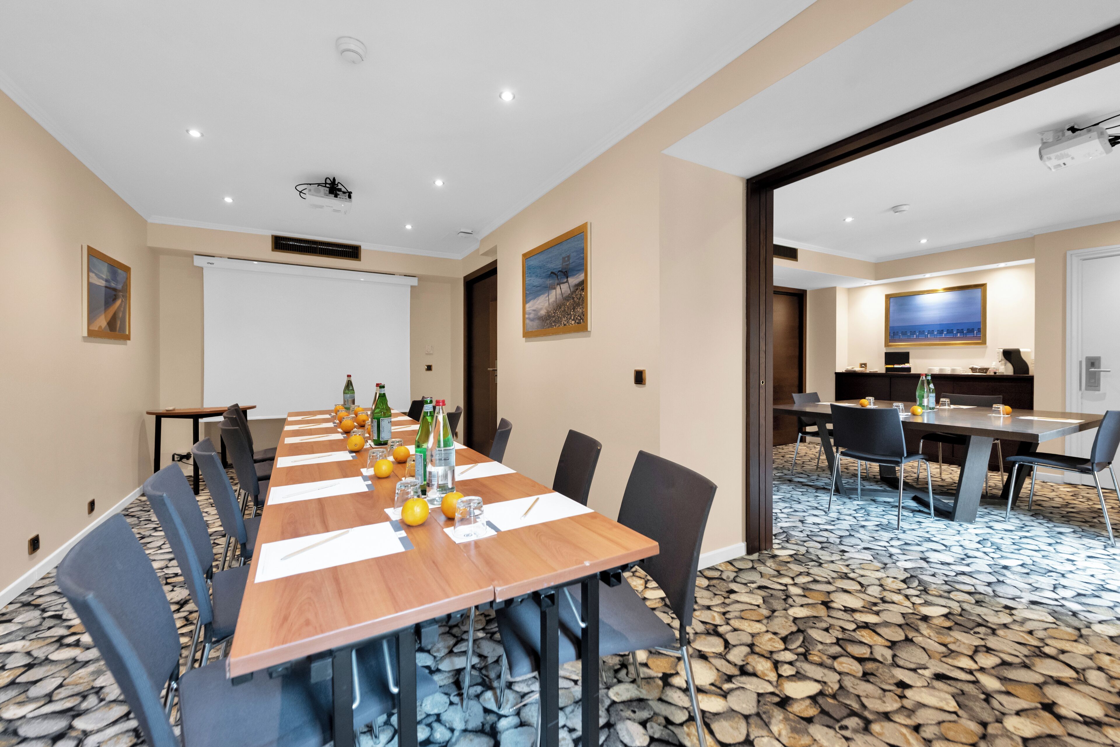 A conference room with a long table, chairs, a projector, and a whiteboard.