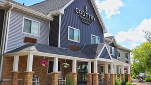 Un bâtiment à deux étages, à la façade bleu foncé, sur lequel on peut lire l’inscription « Country Inn & Suites by Radisson ».