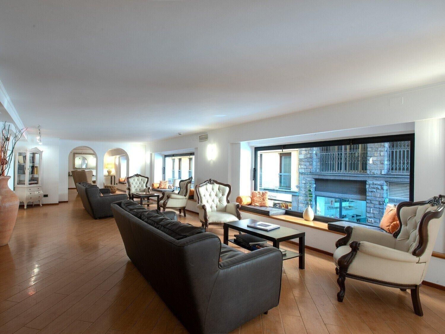 A spacious living room with a fireplace, comfortable seating, and a view of the city.