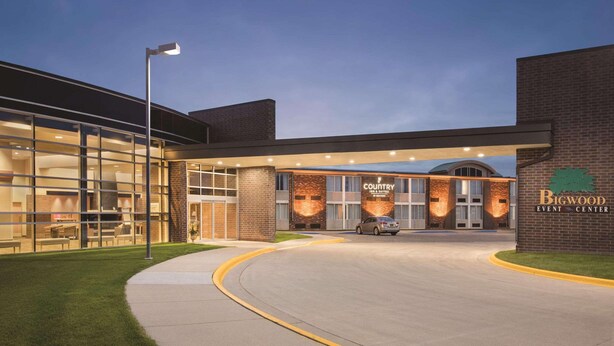 A modern building with a glass facade, a brick exterior, and a sign for the Bigwood Event Center. - Country Inn & Suites by Radisson, Fergus Falls, MN (Fergus Falls)