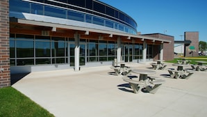 A modern building with large windows and outdoor picnic tables. - Country Inn & Suites by Radisson, Fergus Falls, MN (Fergus Falls)
