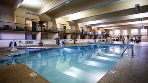 An indoor swimming pool with multiple levels of balconies, lounge areas, and a lifeguard duty sign. - Country Inn & Suites by Radisson, Fergus Falls, MN (Fergus Falls)