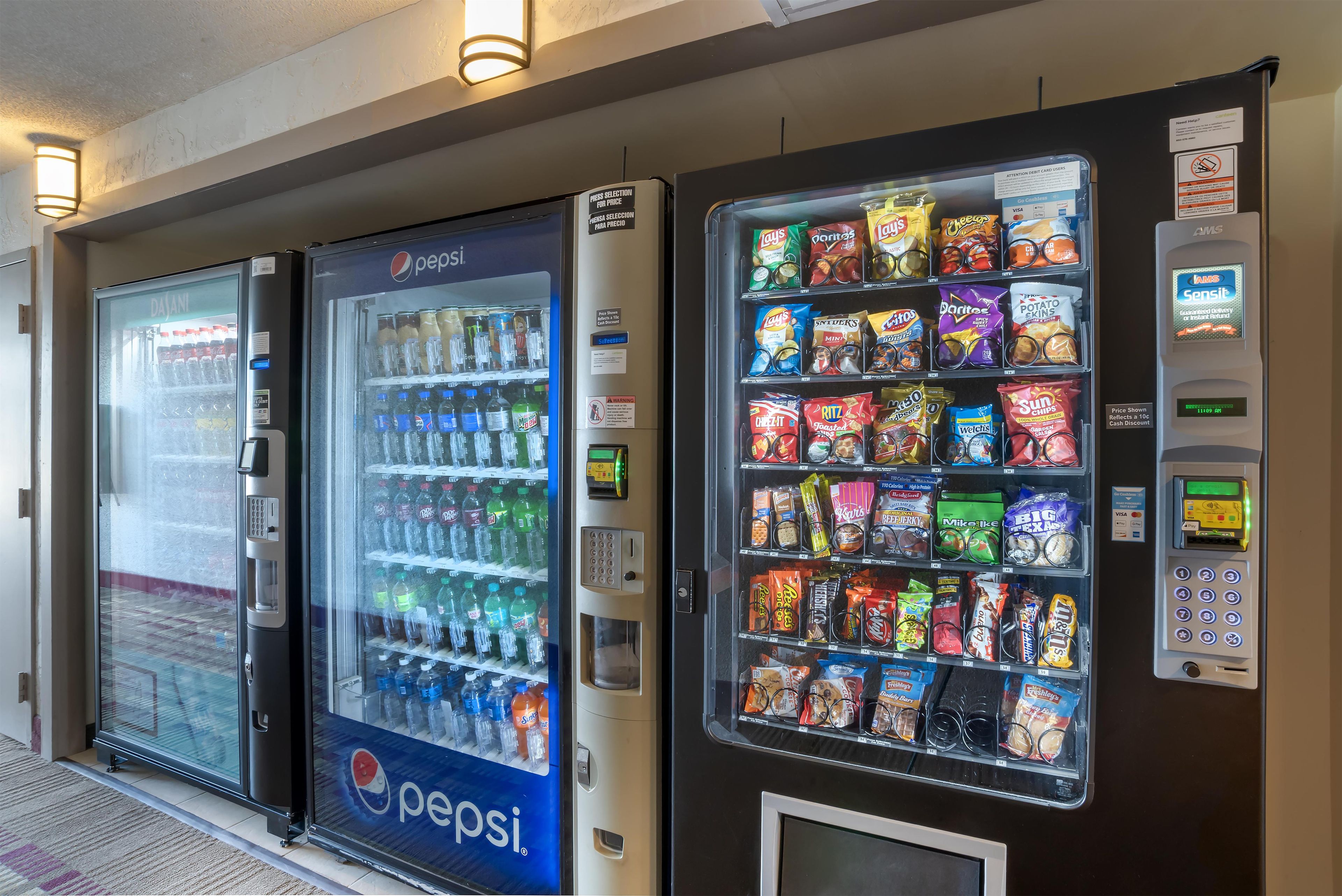 A row of vending machines with various snacks and drinks.
