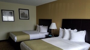 A hotel room with two beds, a nightstand, a lamp, and two framed pictures on the wall. - Best Western Crossroads Inn (De Funiak Springs)