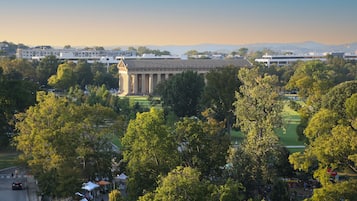 A large building with a classical architectural style, surrounded by lush green trees and a well-maintained lawn.
