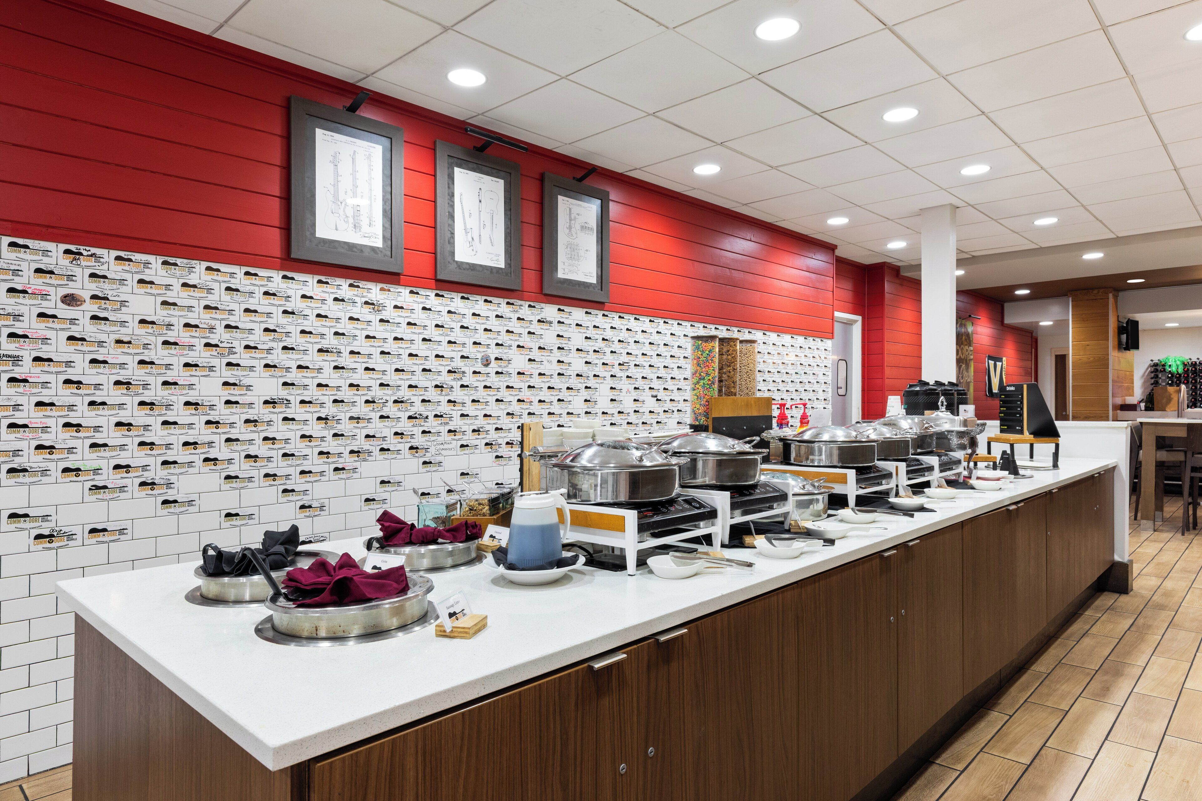 A kitchen area with a long counter, various kitchen utensils, and appliances.