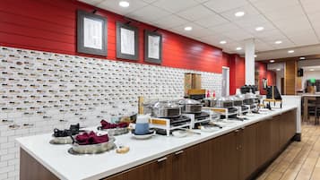 A kitchen area with a long counter, various kitchen utensils, and appliances.