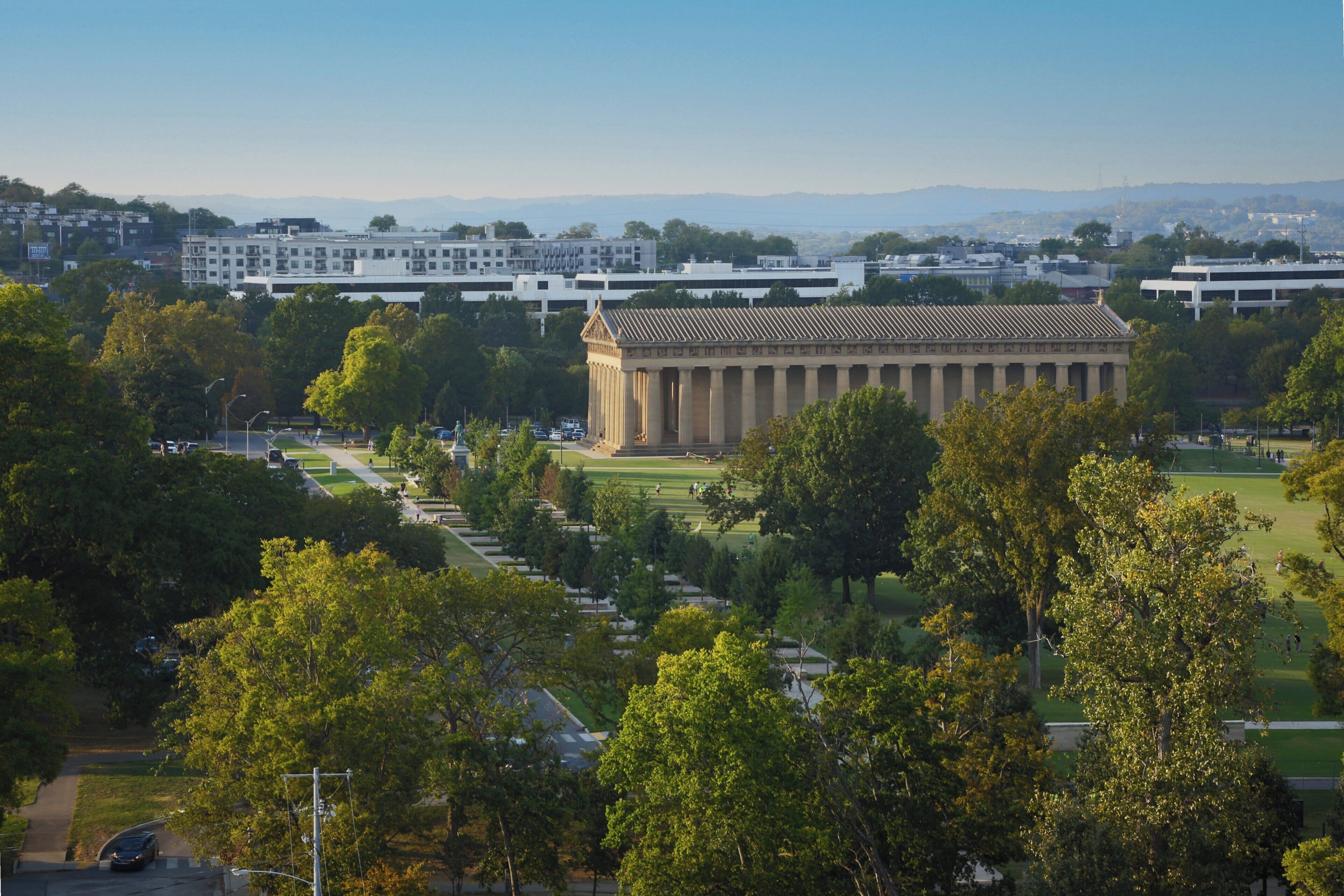 A large building with a classical architectural style, surrounded by a well-maintained lawn and trees.