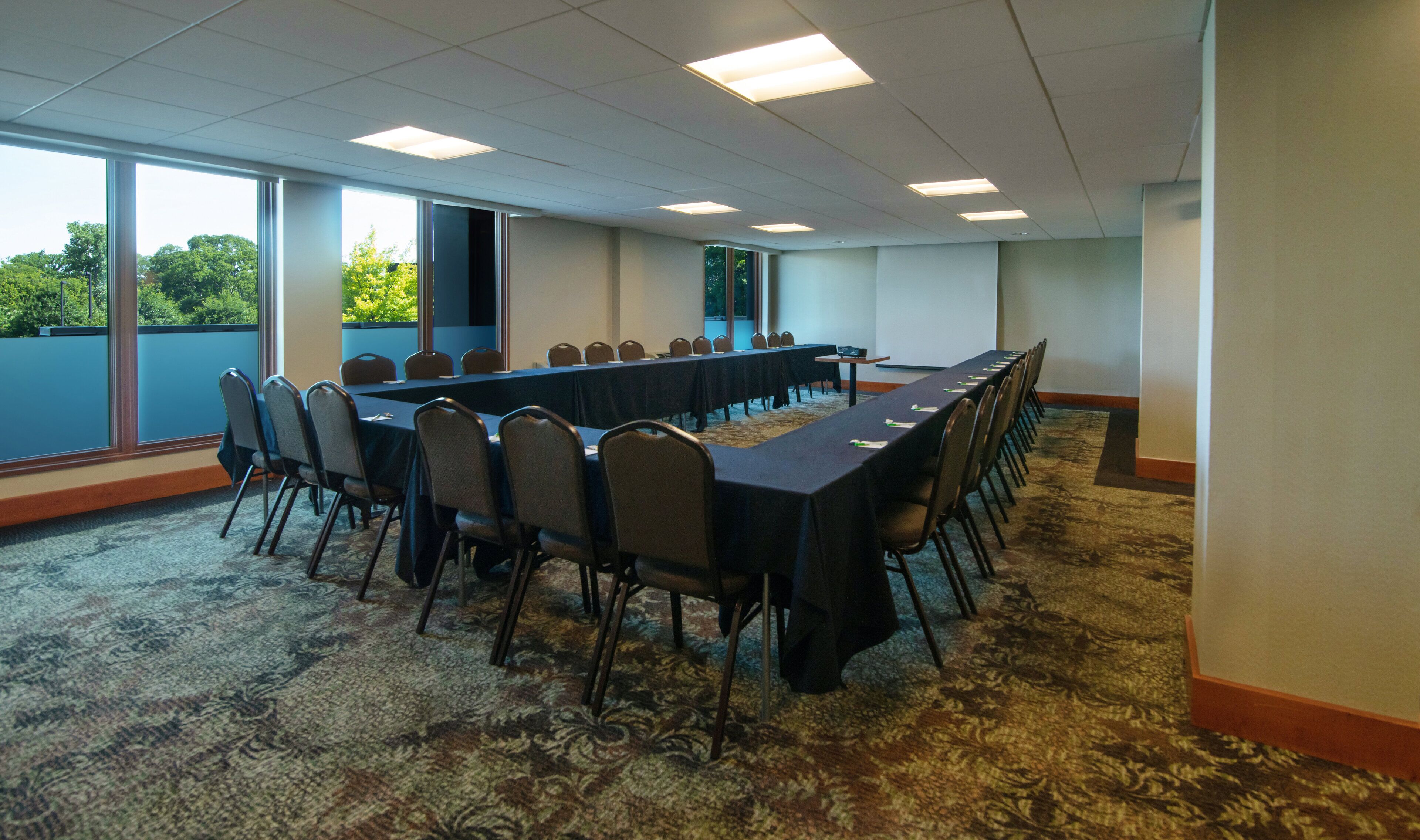 A conference room with a long table, chairs, and large windows.