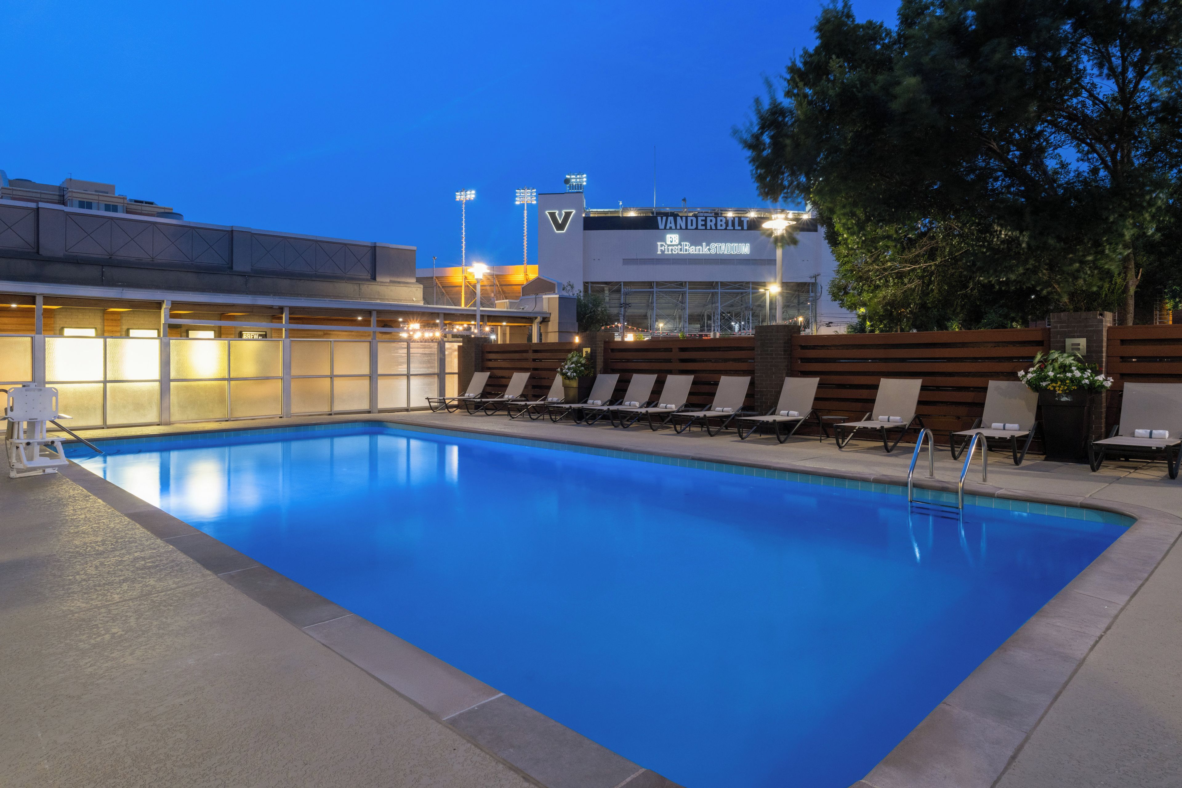 Ein Pool mit Liegestühlen und Blick auf das Vanderbilt FirstBank Stadium.