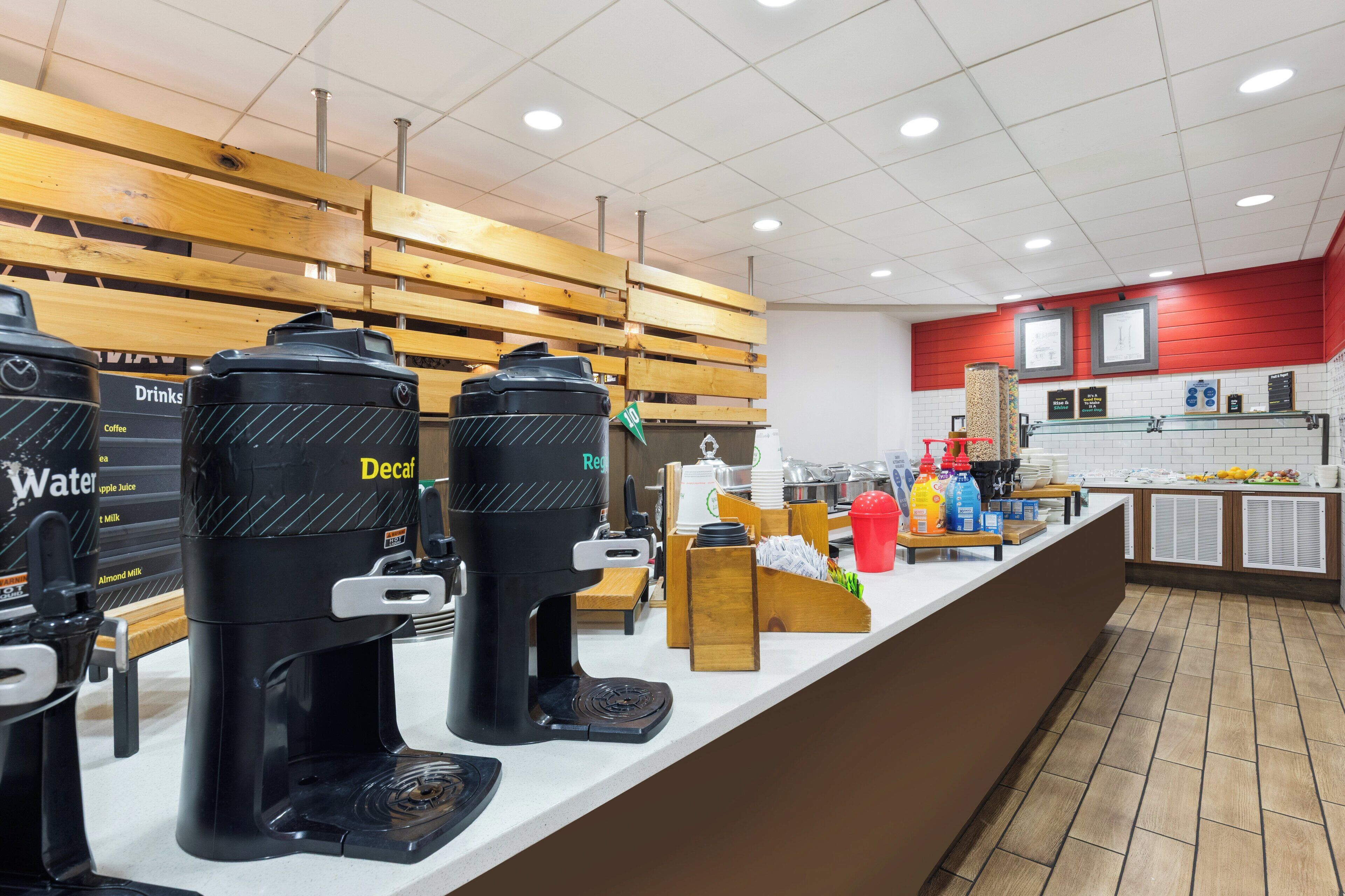 Ein Kaffeeangebot mit mehreren Kaffeemaschinen, einem Wasserspender und einer Theke mit verschiedenen Artikeln.