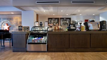 Ein Café-Interieur mit einer Auslage, Espressomaschinen und einem Klavier.