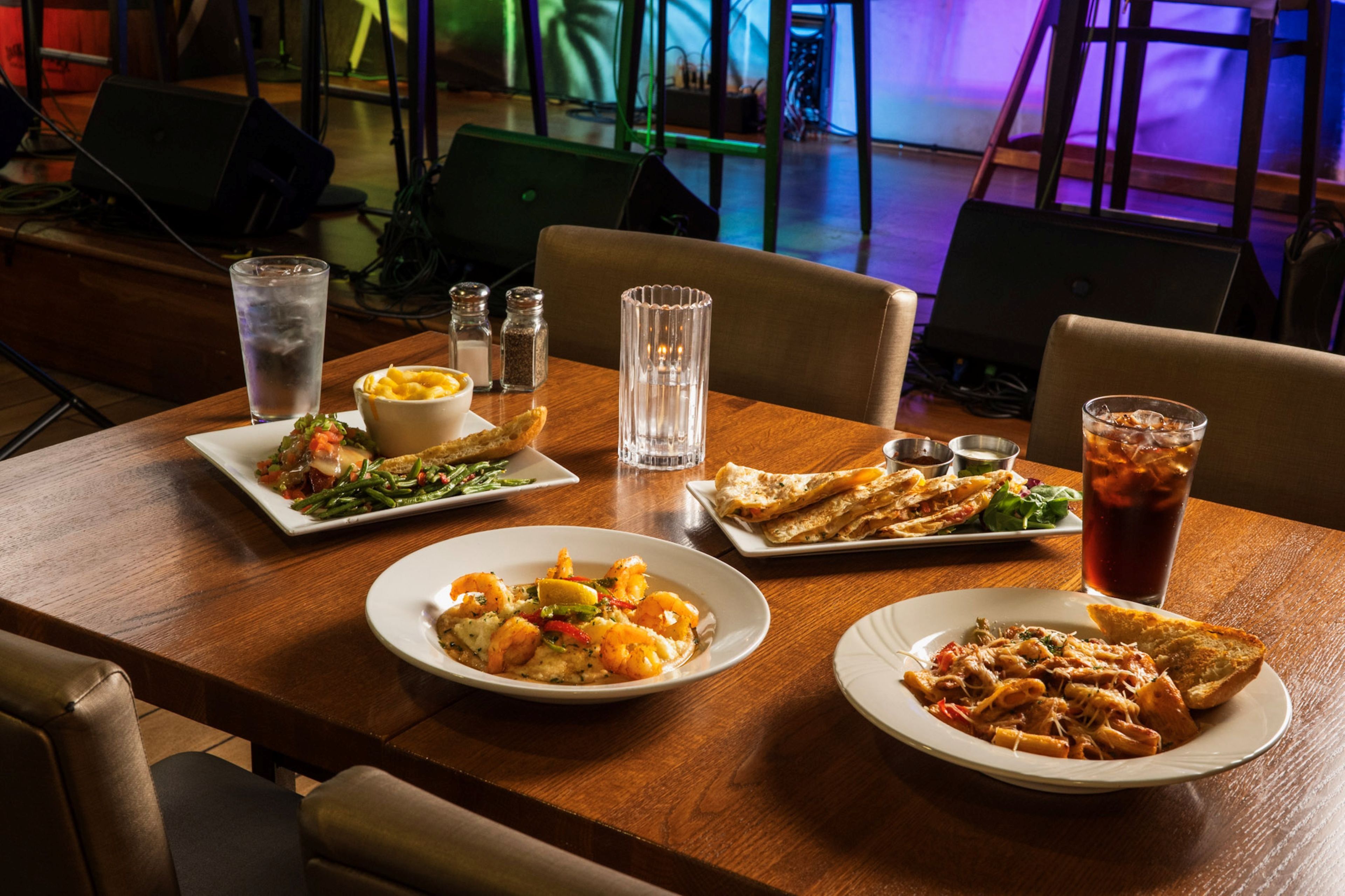 A dining table with various dishes, glasses, and condiments.