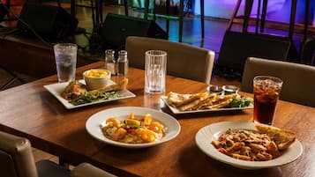 Une table à manger avec différents plats, des verres et des condiments.
