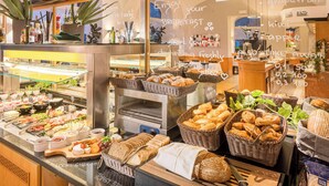A breakfast buffet with various food items and baskets of bread. - Best Western Hotel Moran (Prague)