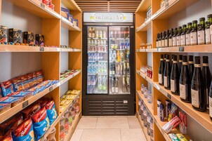 Een winkelinterieur met schappen vol verschillende producten, een koelvitrine en een bord waarop 'minimarket' staat.