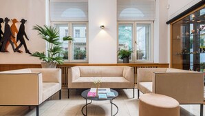 A modern lounge area with a sofa, armchairs, a coffee table, and a potted plant. - Best Western Hotel Moran (Prague)