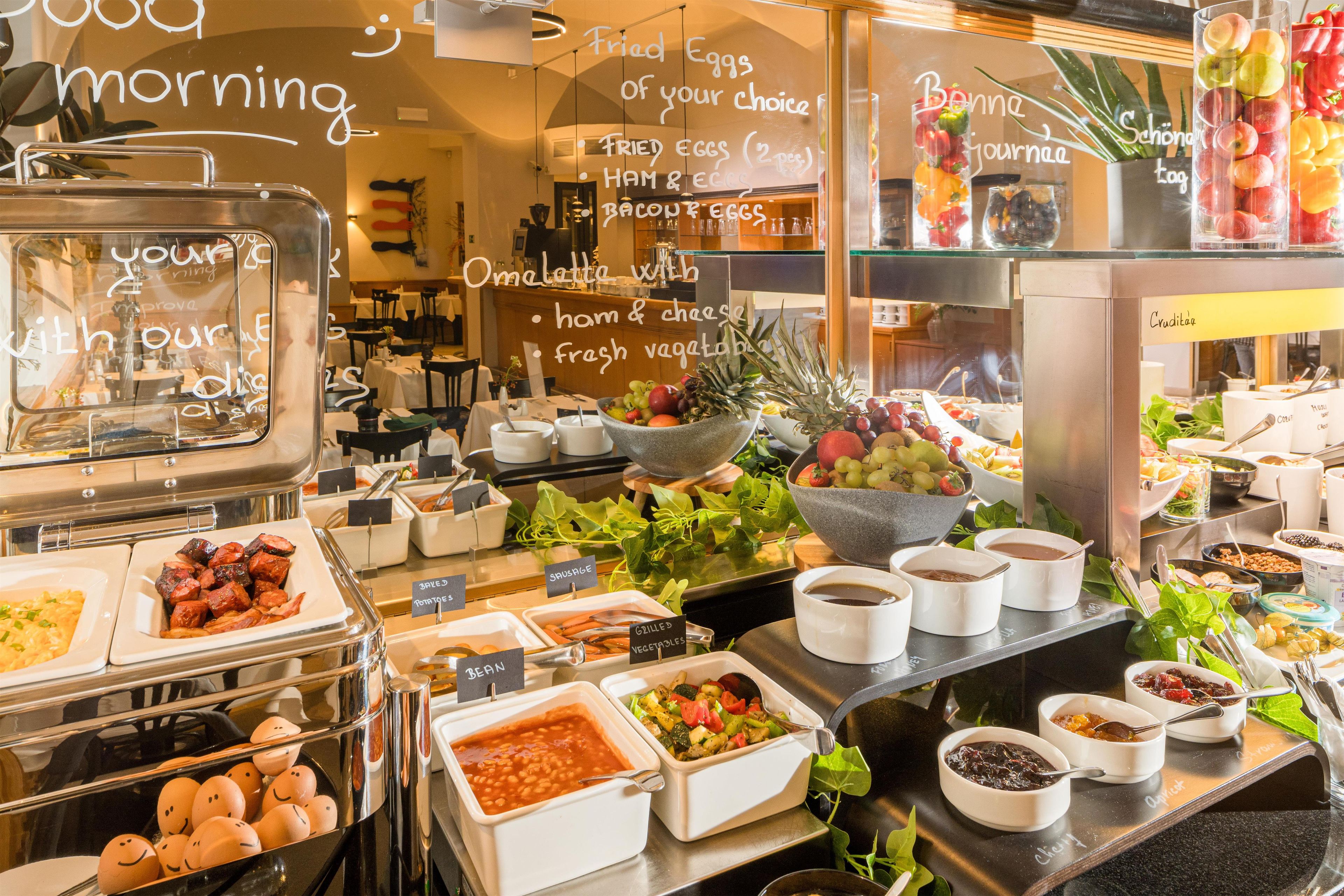 A buffet with various food options including fruits, vegetables, and prepared dishes.